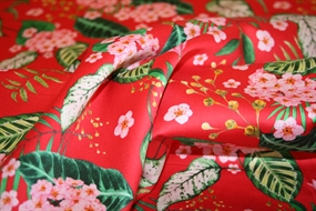 Bomuld med lyserøde blomster på rød bund