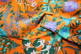 Bomuldsstof med blomster på orange bund