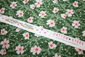Bomulds stof med lyserøde blomster på en grøn mark