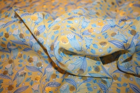 Silke chiffon med guldprikker og blå blomster på en gul bund