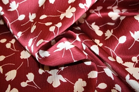Silke stof med stiliserede blomster på en bordeaux bund