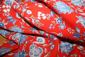 Crepevævet viskose stof med blå blomster på rød bund