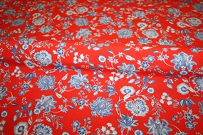 Crepevævet viskose stof med blå blomster på rød bund