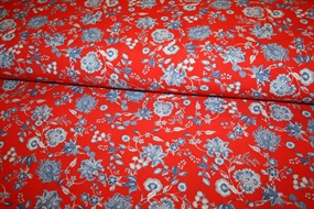 Crepevævet viskose stof med blå blomster på rød bund