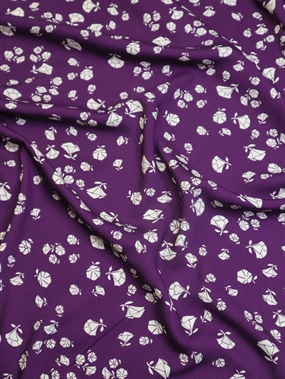 Twillvævet viskose med små hvide blomsteromrids på lilla bund